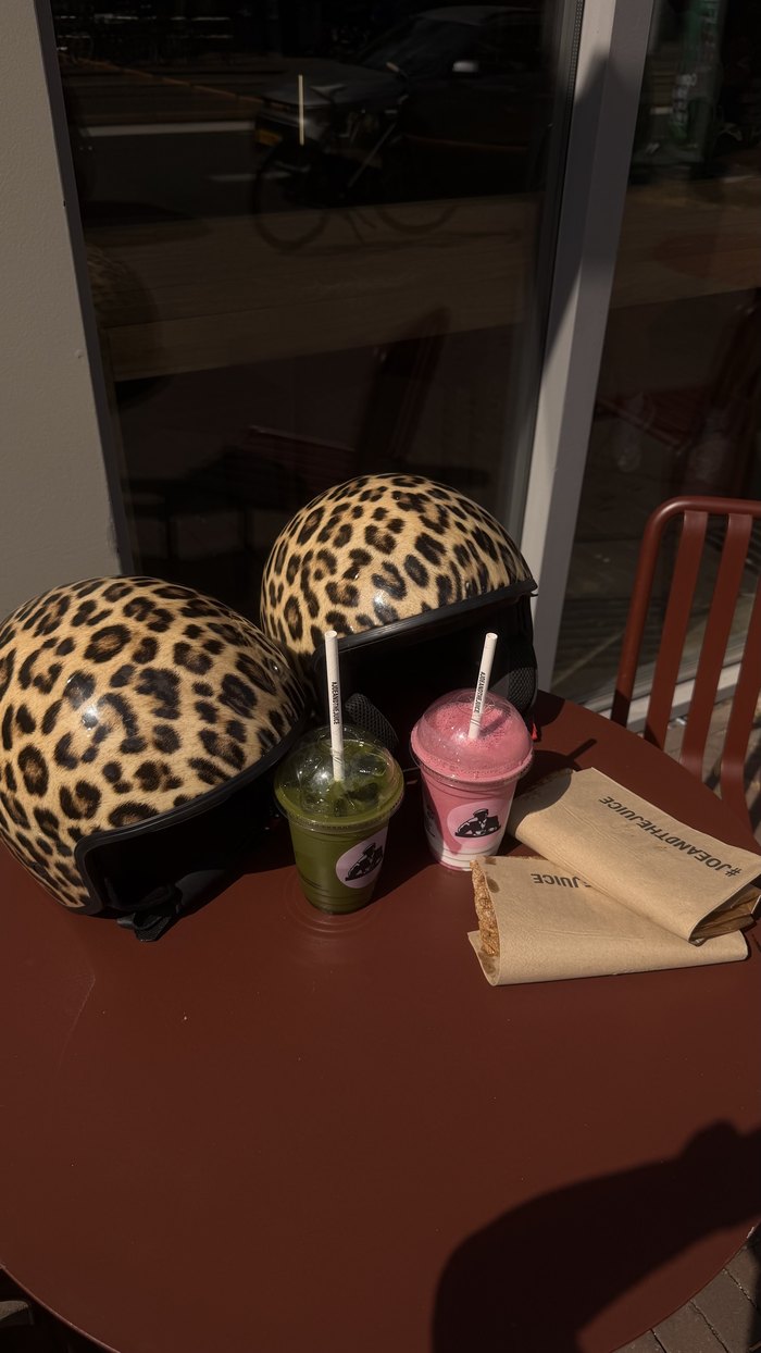 Two Leopard Scooter Helmpies on a cafe table in Amsterdam